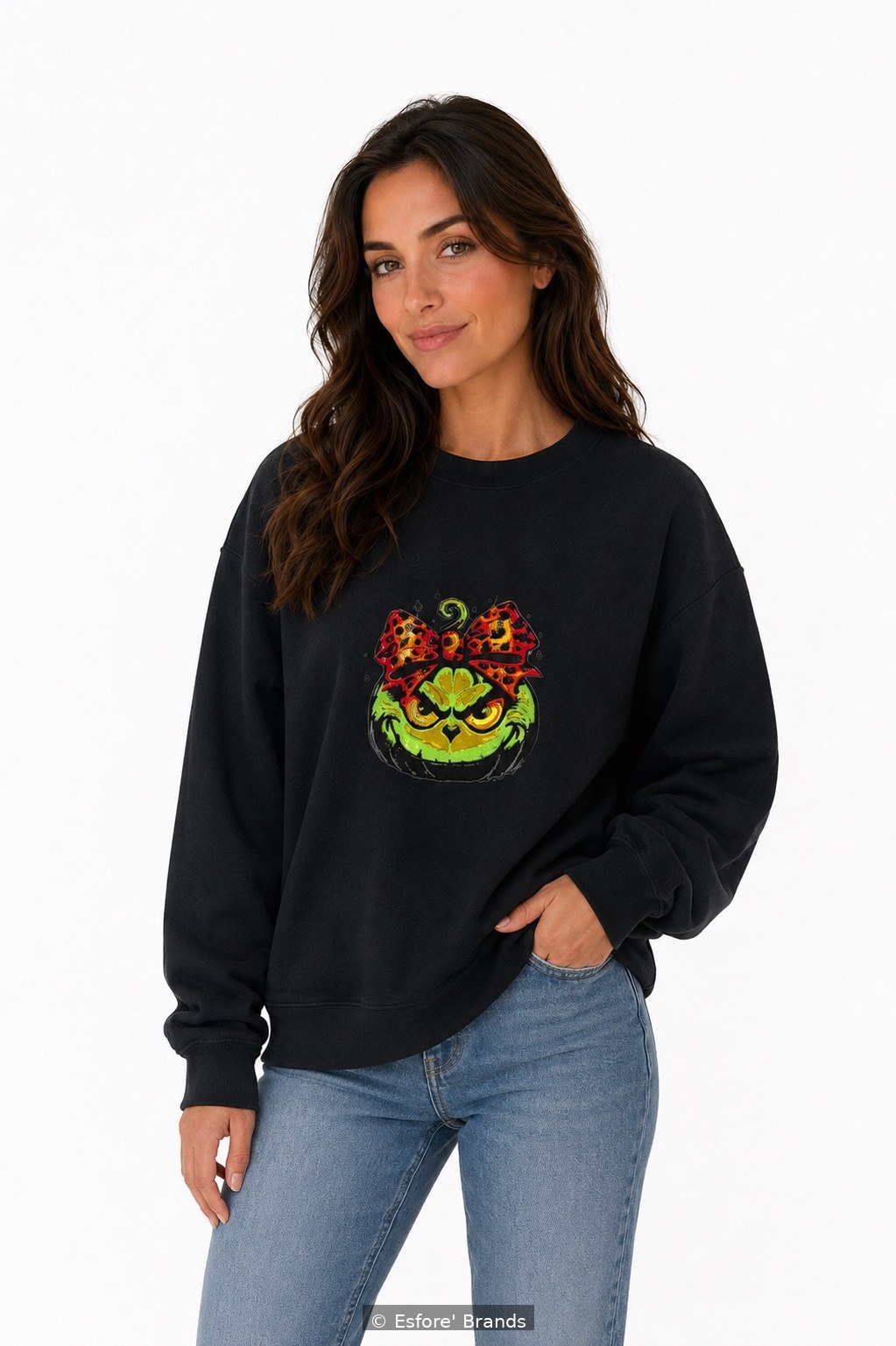 Model wearing the Grinch Pumpkin embroidered sweatshirt — the same embroidery is stitched on the T-shirt